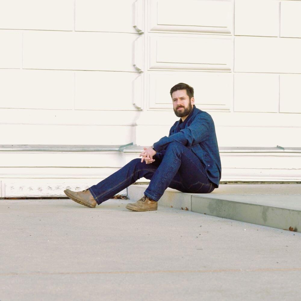 Model sits on step with sustainable classic jeans